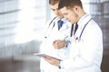 Two doctors with stethoscopes discuss medical exam resoults standing at hospital office. Physician and his colleague use Royalty Free Stock Photo