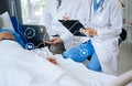 Two doctors talking to a patient lying in his bed with receiving saline solution in a hospital Royalty Free Stock Photo