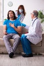 Two doctors visiting sick young man at home Royalty Free Stock Photo