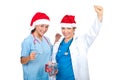 Two doctors women with Santa hats cheering