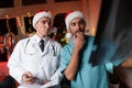 Two doctors work on New Year`s Eve and discuss an X-ray that is held in hands. Royalty Free Stock Photo