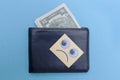 Two dollars are in the wallet. Sad smiley looks at the wallet. Blue background. Bankrupt. Money is tight. Importance of