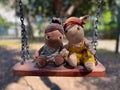 Two dolls on a swing on a sunny summer day. Royalty Free Stock Photo