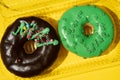 Two donuts chocolate and green on a yellow background in a box close-up. Studio horizontal photo Royalty Free Stock Photo