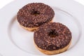 Two donuts with chololate glaze on white plate