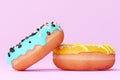 Two donuts with colorful icing on white background. Chocolate donut with violet icing and donut with white chocolate icing.