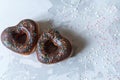 two donuts in a heartshape on a gray background. Concept for Valentine's Day. Valentine's Day bakery. space for
