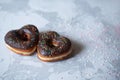 two donuts in a heartshape on a gray background on a white plate. Concept for Valentine's Day. Valentine's Day Royalty Free Stock Photo