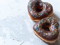 two donuts in a heartshape on a gray background on a white plate. Concept for Valentine& x27;s Day. Valentine& x27;s Day Royalty Free Stock Photo