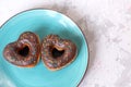 two donuts in a heartshape on a gray background on a white plate. Concept for Valentine's Day. Valentine's Day Royalty Free Stock Photo