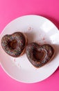 two donuts in a heartshape on a white plate and on a pink background. Concept for Valentine's Day. Valentine's Royalty Free Stock Photo