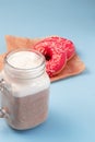 Two donuts with pink fondant and white sprinkles on crumpled parchment paper Royalty Free Stock Photo