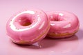 two donuts on a pink surface