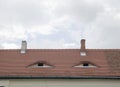 Two dormers with windows on repaired brown ceramic roof Royalty Free Stock Photo