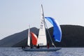 Two dragon boats with colored spinnaker sailing and competing for Dragon Cup in Bodrum, Turkey