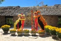 Two dragon costume for the celebration of the Asian New Year. Vases with live yellow flowers around dragons - new year symbol.