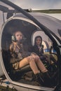 Two dreamy tween girls on pilot seats in helicopter cockpit