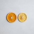 Two dried citrus slices are placed on a light grey textured surface. The left slice is Royalty Free Stock Photo