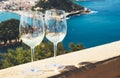 Two drink glass white wine standing on background blue sea top view city coast yacht from observation deck, romantic toast Royalty Free Stock Photo