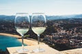 Two drink glass white wine standing on background blue sea top view city coast yacht from observation deck, romantic toast