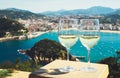 Two drink glass white wine standing on background blue sea top view city coast yacht from observation deck, romantic toast