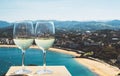 Two drink glass white wine standing on background blue sea top view city coast yacht from observation deck, romantic toast Royalty Free Stock Photo