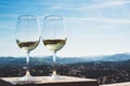 Two drink glass white wine standing on background blue sea top view city coast yacht from observation deck, romantic toast