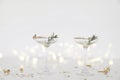 Two drinking glasses with champagne, bubbly wine. White table. Golden star shape confetti. Blurred background with bokeh