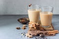 Two drinking glasses with traditional Indian drink - masala chai tea milk tea with spices for making tea. Royalty Free Stock Photo