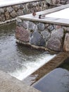 Two ducks male and female sleeping on the side of stone surface sides water channel (canal) by winter time with Royalty Free Stock Photo