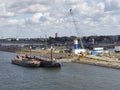 Two Dutch Barges moored next to a floating Pier near to the Construction site of the new Sea lock