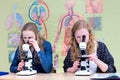 Two dutch teenage girls looking through microscope Royalty Free Stock Photo