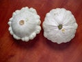 Two Early White Scallop Squash vegetables on the brown wooden background