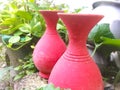 Two earthen pots of red color placed outside in a garden for decoration and beauty