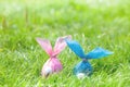 Two Easter eggs in the form of rabbits made of paper, hiding in the grass Royalty Free Stock Photo