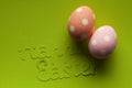 Two Easter eggs and inscription on green paper Royalty Free Stock Photo