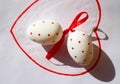 Two Easter white eggs with red dots on white background in red heart Royalty Free Stock Photo