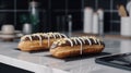 Two eclairs with chocolate icing and white chocolate on the table close-up. Royalty Free Stock Photo