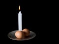 Two eggs and a candle, circumcision ceremony symbols. Black back