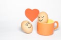 Valentines day concept with eggs resembles a couple looking each other with love, with a red heart shaped background Royalty Free Stock Photo