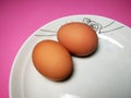 Two eggs in a white plate