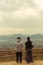 Two elder asian women standing in back side and look to the mountain view on overcast day with fog and cloudy.