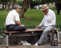 Two elderley men play Go in a park