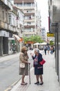 Two elderly women chat in a street