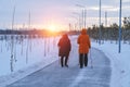 Two elderly women are engaged in sports walking in park, evening at sunset in winter Royalty Free Stock Photo
