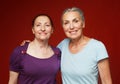 Two elderly women friends on red background. Lifestyle concept. Royalty Free Stock Photo