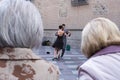 Two elderly women looking at tango dancers