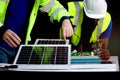 Two electrical engineers working with electronic circuit board and solar cells, mechanicals senior white and African American men