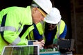 Two electrical engineers working with electronic circuit board and solar cells, mechanicals senior white and African American men