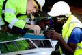 Two electrical engineers working with electronic circuit board and solar cells, mechanicals senior white and African American men